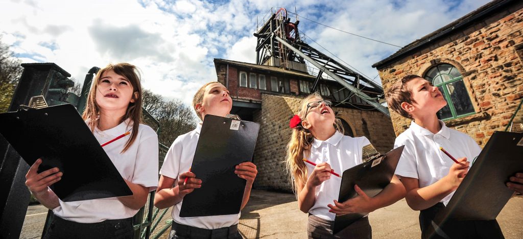 School Trip in Pit Yard, looking up to the skies and holding clip boards