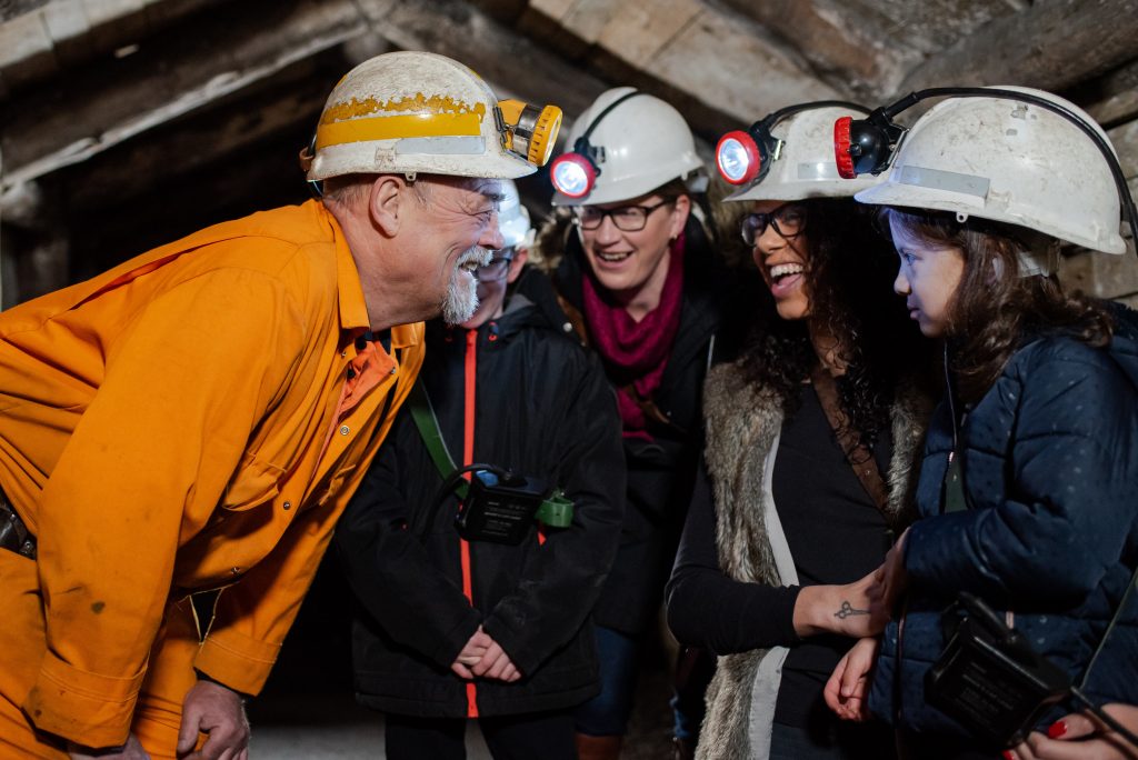 Miner laughs with visitors underground