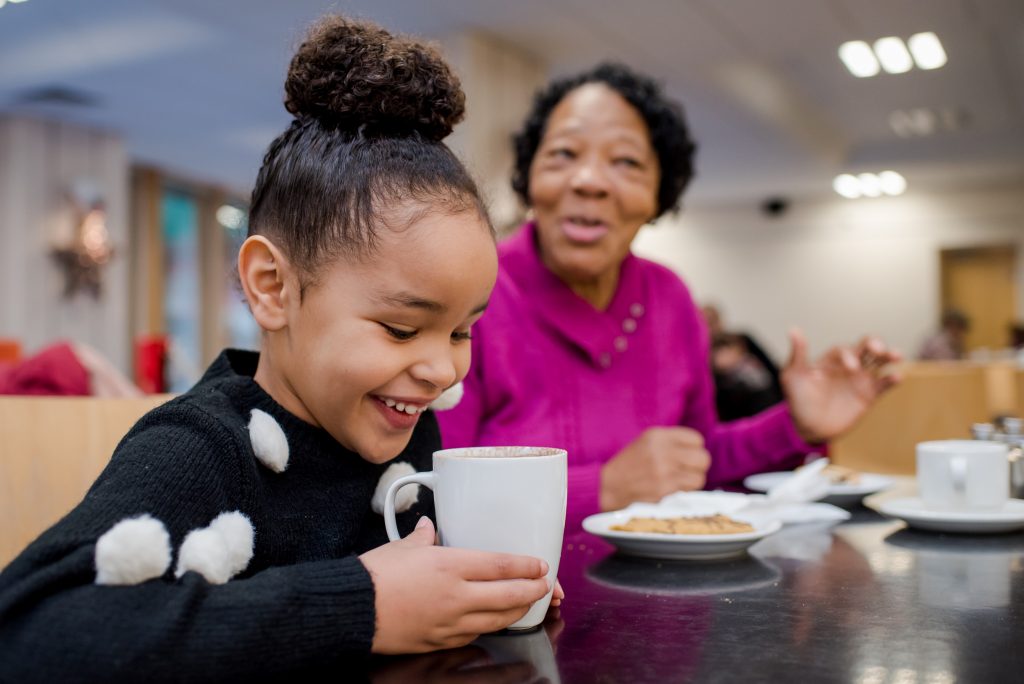 Two visitors (child and adult) enjoying treats in the Café