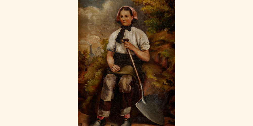 Woman seated holding a shovel, in the background the colliery buildings are visible.