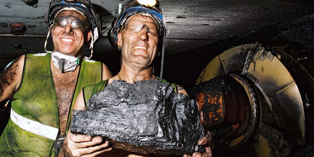 Two miners holding a large lump of coal by a large machine. Kellingley 2011 - Martyn Pitt