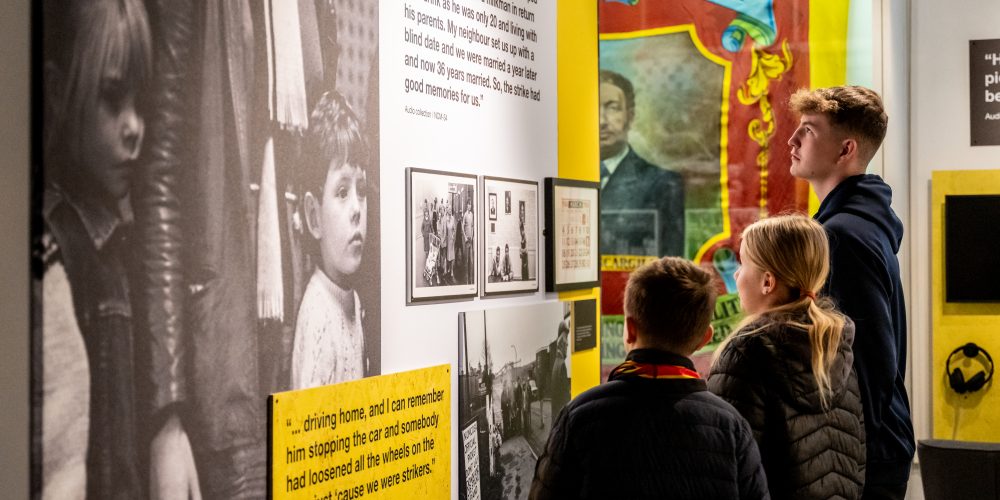 A group of three children looking at the gallery walls.