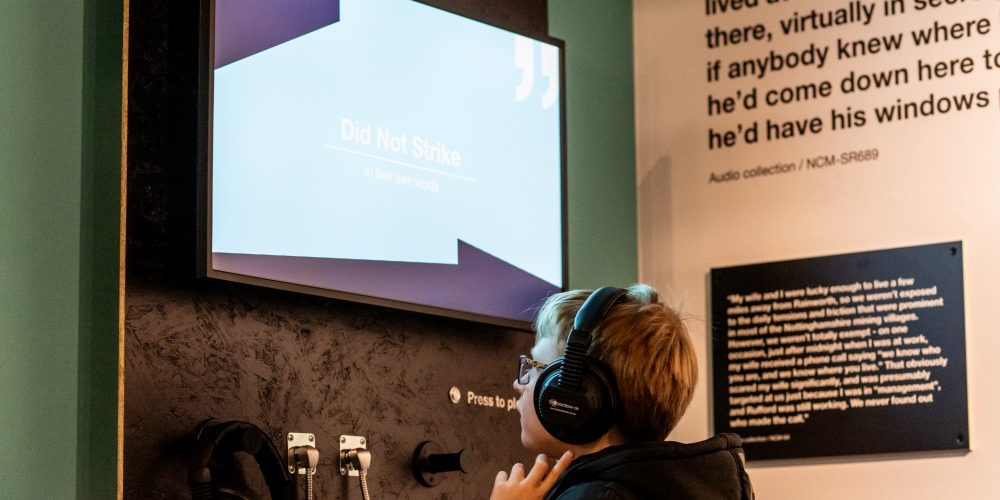 child wearing headphones seated in the exhibition.