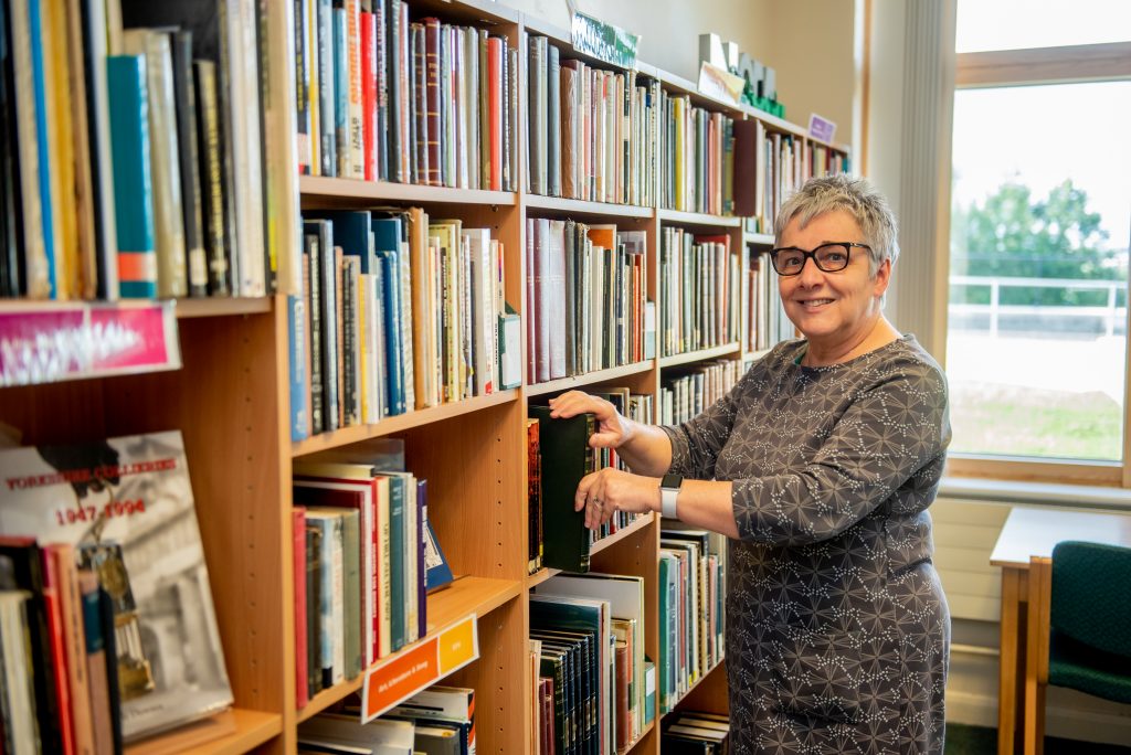 Jill, our librarian stood, with books