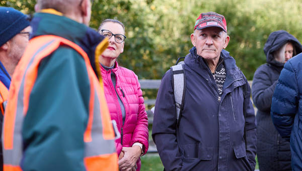 Two people listening to a guide along the nature trail