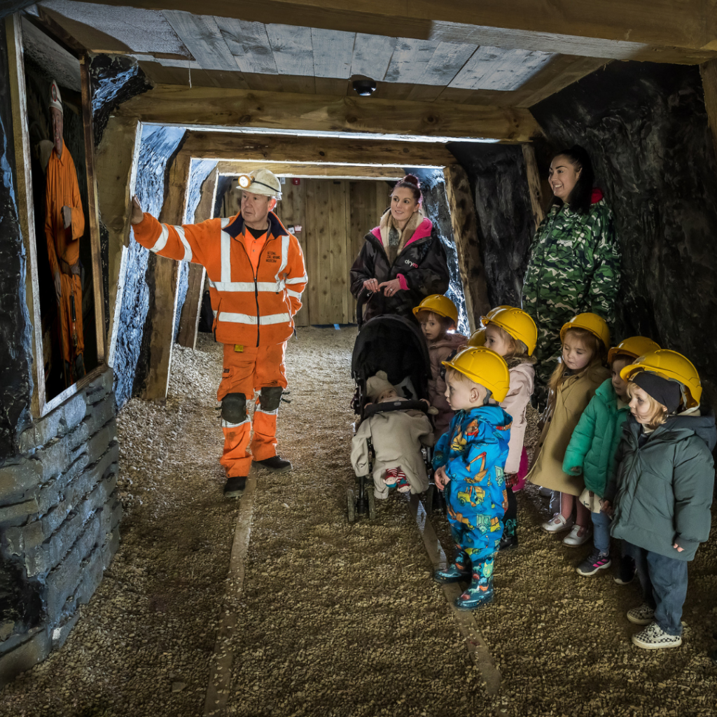Time Tunnel tour with a miner with a group of young children including a baby in a pram