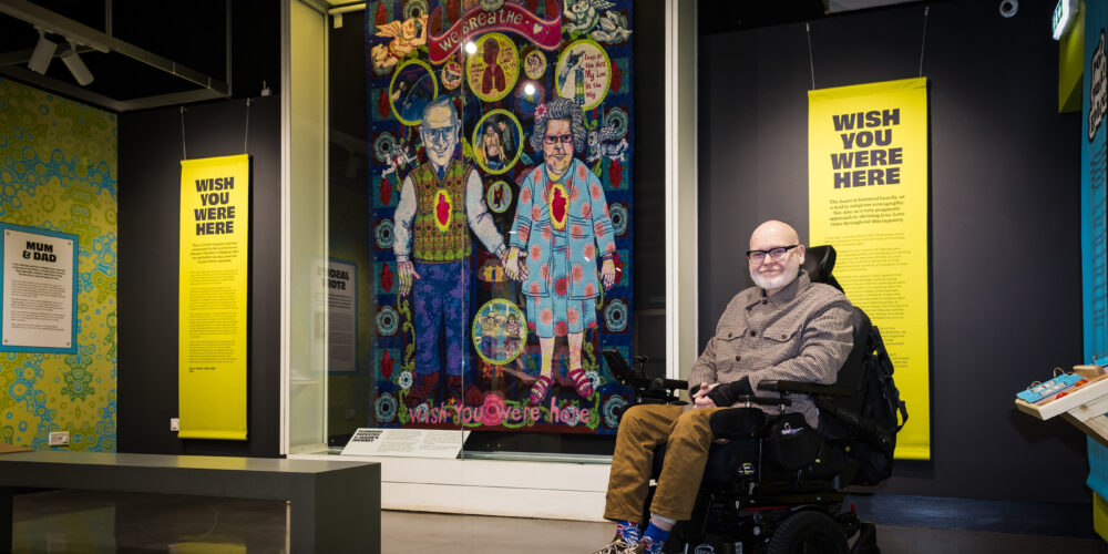 Jason in front of the tapestry depicting memories of his family