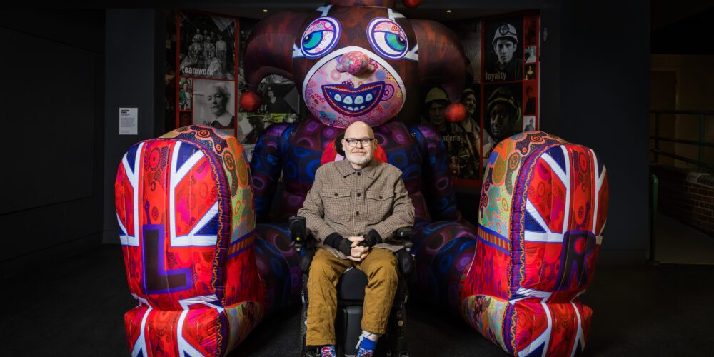 Jason in front of a jester inflatable - blue and red in colour